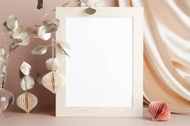 Portrait empty wooden frame mockup with honeycomb paper decor and textile on beige background, interior, Christmas home design. space for text. 