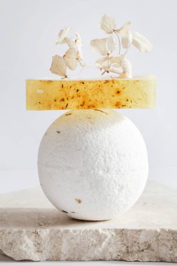 Banyo bombası, el yapımı sabun, yağ ve mum beyaz arka planda podyumda. Hayat, spa, rahatlama konsepti