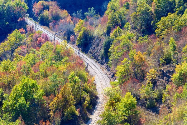 Eisenbahnlinie durch eine bunte Berglandschaft an einem Herbsttag — Stockfoto