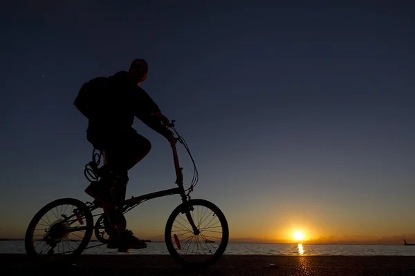 Silhouette of the cyclist riding a road bike at sunset — Stock Photo, Image