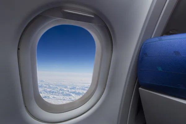 Janela de avião com asa e céu nublado atrás — Fotografia de Stock