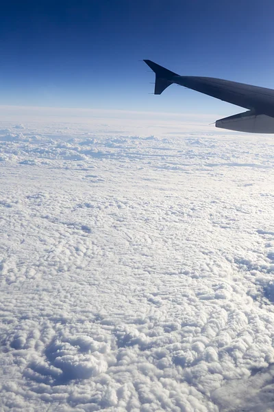 Vleugel van het vliegtuig dat boven de wolken in de lucht vliegt — Stockfoto