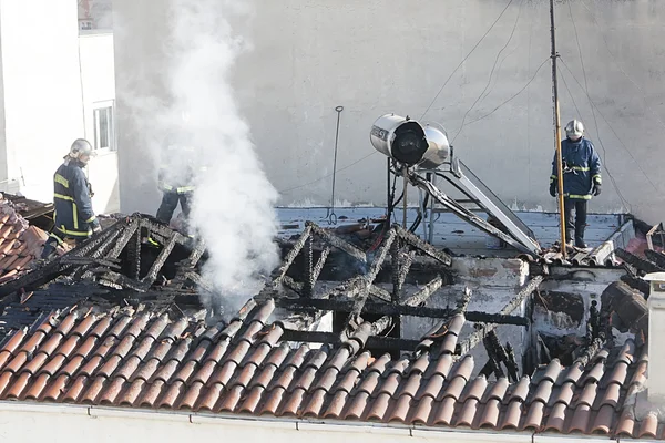 Bomberos tratan de extinguir el fuego en un piso quemado — Foto de Stock