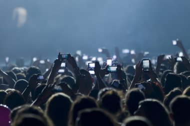 Bir müzik sırasında dokunmatik akıllı telefon ile fotoğraf çekmeye kişi 