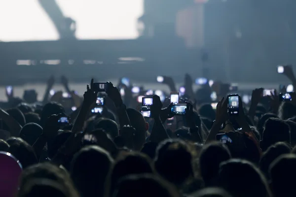 Pessoas tirando fotos com telefone inteligente de toque durante uma música — Fotografia de Stock