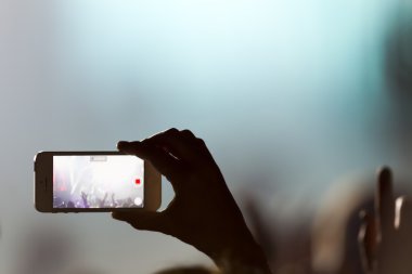 Bir müzik sırasında dokunmatik akıllı telefon ile fotoğraf çekmeye kişi 