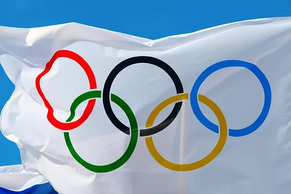 Weiße olympische flagge gegen den blauen himmel in athens, griechenland. — Stockfoto