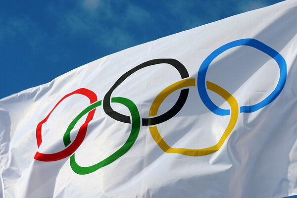 White Olympics Flag against the blue sky in Athens, Greece.
