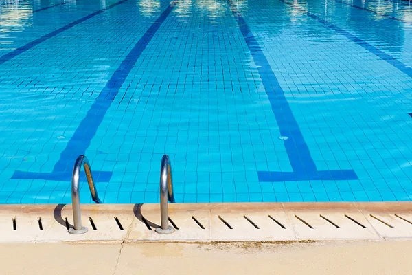 Piscina com escada e reflexos ensolarados — Fotografia de Stock