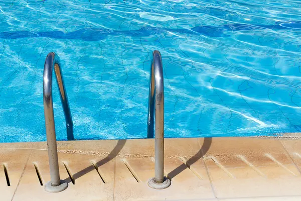 Swimming pool with stair and sunny reflections — Stock Photo, Image