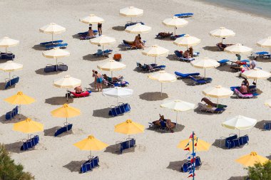 turistler, şezlong ve şemsiye ile plaj. beklenen 