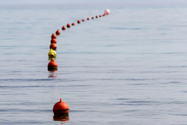 Red buoy row floating in blue sea in line. — Stock Photo, Image