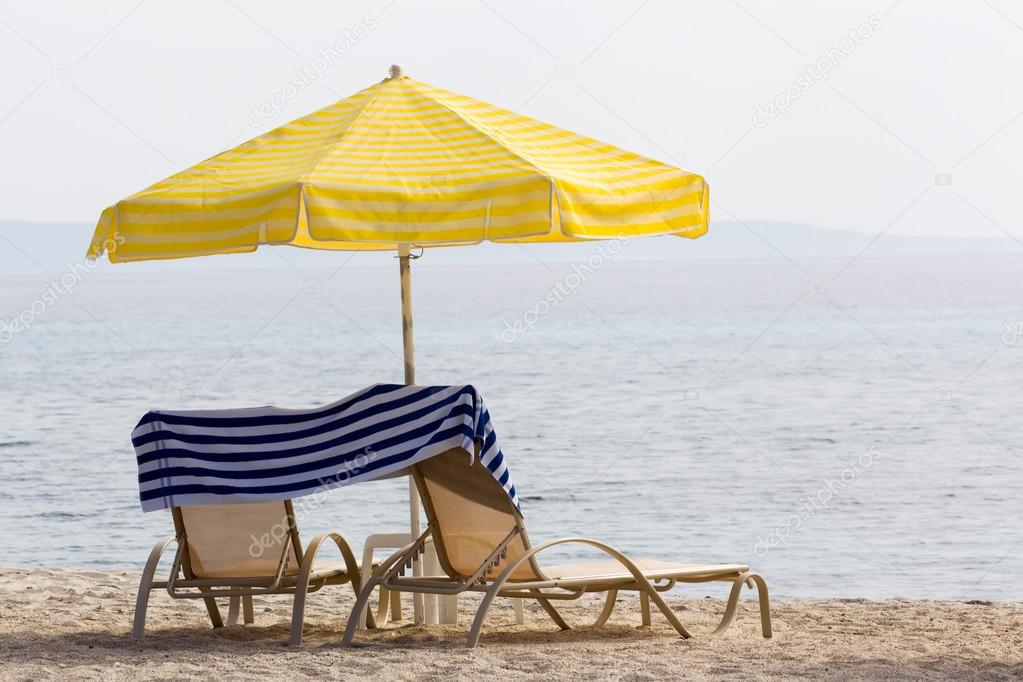 Sunchairs and umbrella on beach
