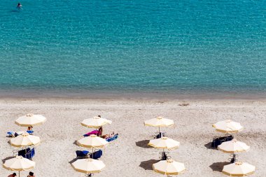 turistler, şezlong ve şemsiye ile plaj. beklenen 