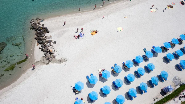 Вид сверху на пляж с туристами, сандалиями и умбреллами. Морской трав — стоковое фото