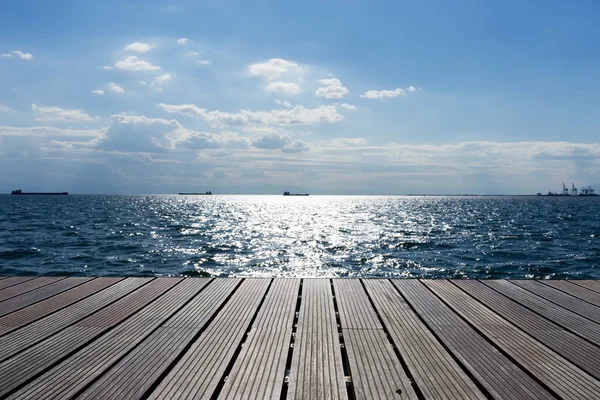 Houten platform naast de Oceaan en blauwe hemel — Stockfoto