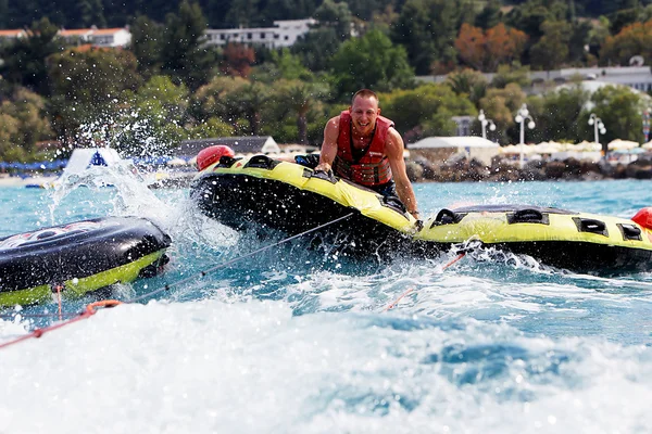 Group of unrecognized people bouncing up over wake on tubes. 20 — Stock Photo, Image