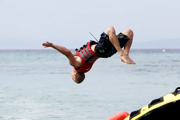 Unrecognized man doing back flip over water. 20 million tourist — Stock Photo, Image