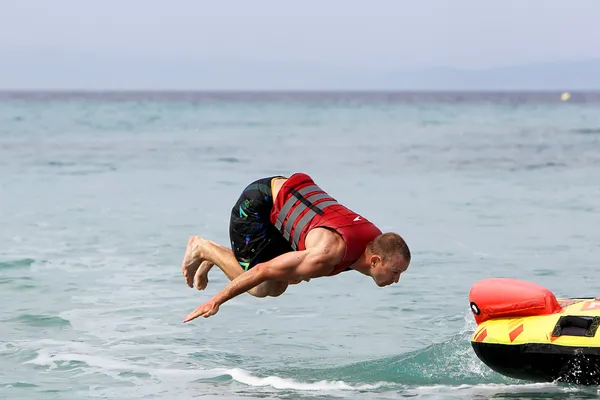 Unrecognized man doing back flip over water. 20 million tourist — Stock Photo, Image