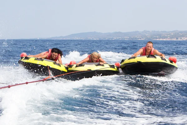 Group of unrecognized people bouncing up over wake on tubes. 20 — Stock Photo, Image