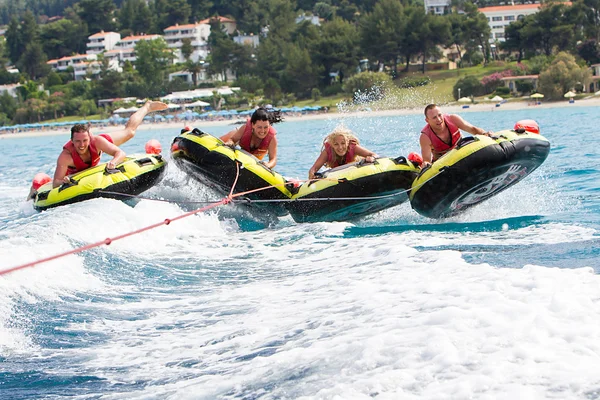 Group of unrecognized people bouncing up over wake on tubes. 20 — Stock Photo, Image