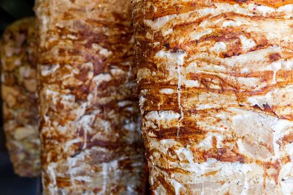 A pair of rotating skewered chicken and lamb meat grilled and re — Stock Photo, Image