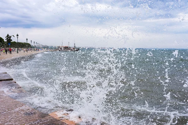 Forsande surfa på en våg slå mot hamnen i thessaloniki, — Stockfoto