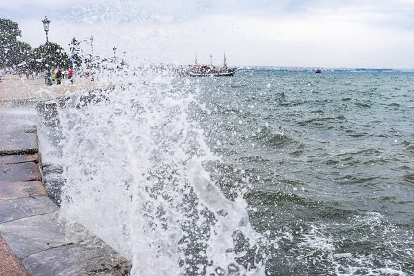 Forsande surfa på en våg slå mot hamnen i thessaloniki, — Stockfoto