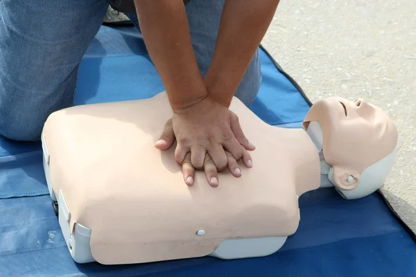 Male instructor showing CPR on training doll — Stock Photo, Image