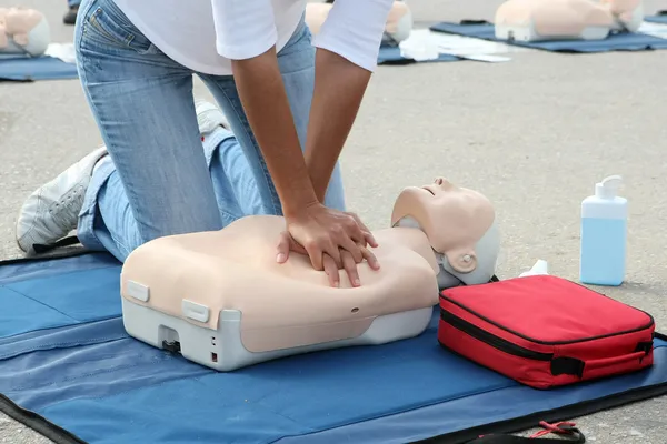 Female instructor showing CPR on training doll — Stock Photo, Image