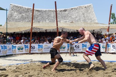iki erkek sporcular kum üzerinde birinci dünya champio sırasında güreşmek.