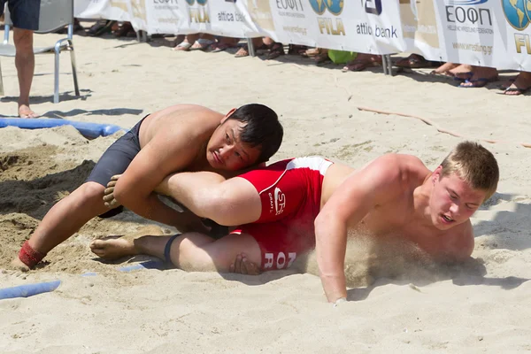 Deux athlètes masculins luttent sur le sable pendant le premier champion du monde — Photo