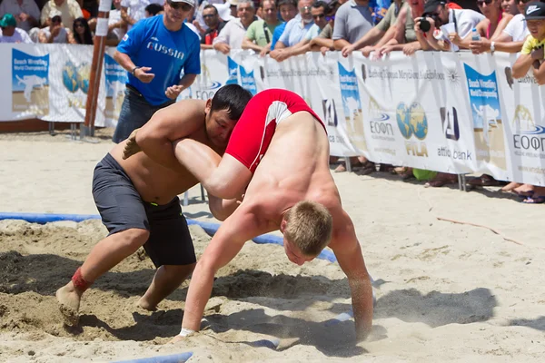 Deux athlètes masculins luttent sur le sable pendant le premier champion du monde — Photo