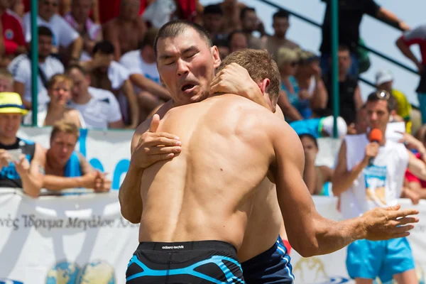 Twee mannelijke atleten worstelen op zand tijdens de eerste champio van de wereld — Stockfoto