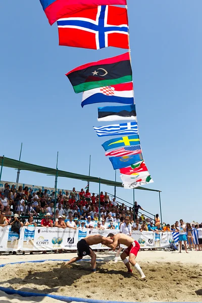 Twee mannelijke atleten worstelen op zand tijdens de eerste champio van de wereld — Stockfoto