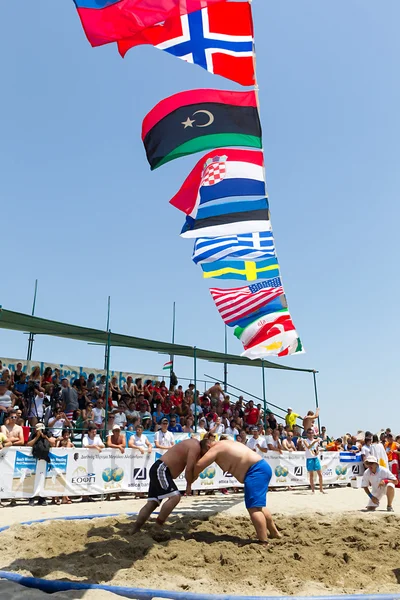 Twee mannelijke atleten worstelen op zand tijdens de eerste champio van de wereld — Stockfoto