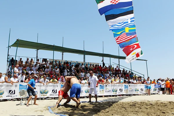Deux athlètes masculins luttent sur le sable pendant le premier champion du monde — Photo