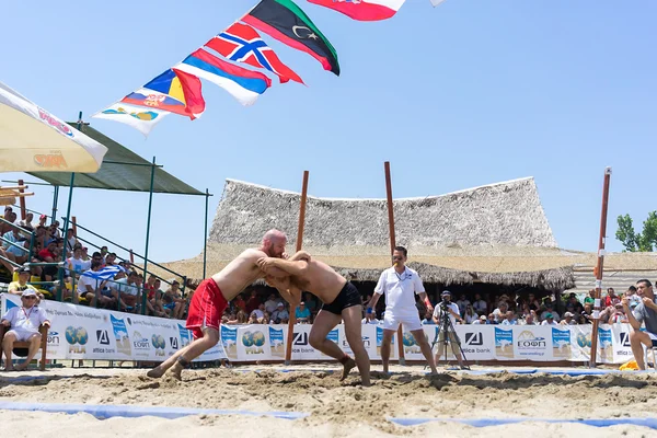Zwei männliche Athleten ringen bei der ersten Weltmeisterschaft auf Sand — Stockfoto