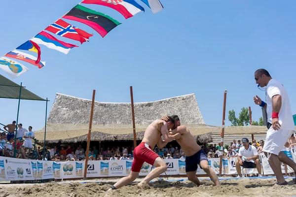 Deux athlètes masculins luttent sur le sable pendant le premier champion du monde — Photo