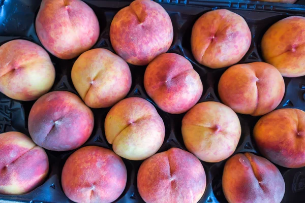 Vers geoogste perziken in een krat — Stockfoto