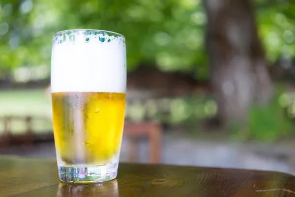 Vidro de cerveja na mesa de madeira — Fotografia de Stock