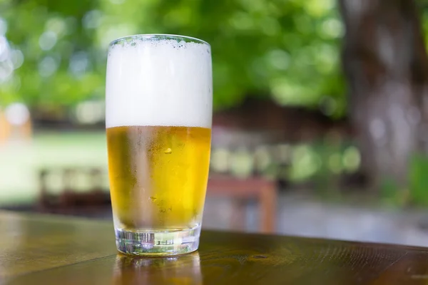 Vidro de cerveja na mesa de madeira — Fotografia de Stock