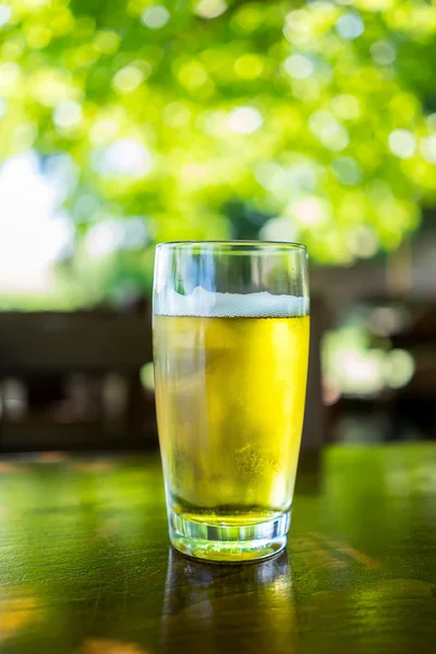 Vidro de cerveja na mesa de madeira — Fotografia de Stock