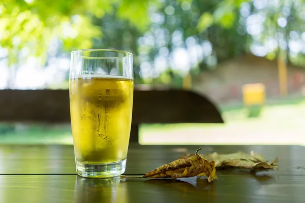 Vidro de cerveja na mesa de madeira — Fotografia de Stock