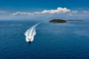 Sürat teknesi su üstünde daha hızlı hareket ediyor. Sürat teknesi hız suyu. Sürat teknesi suda hareket ediyor. Sürat teknesi koyu mavi hava manzaralı. Lichadonisia, Kuzey Evia, Yunanistan