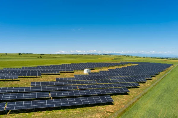 北ギリシャの緑のフィールドに空中ビューの太陽光発電パネル公園 太陽電池パネルの列に反映青い空 未来的な代替発電所だ 持続可能なエネルギー源 再生可能エネルギー技術 — ストック写真