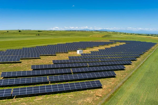 北ギリシャの緑のフィールドに空中ビューの太陽光発電パネル公園 太陽電池パネルの列に反映青い空 未来的な代替発電所だ 持続可能なエネルギー源 再生可能エネルギー技術 ストック画像