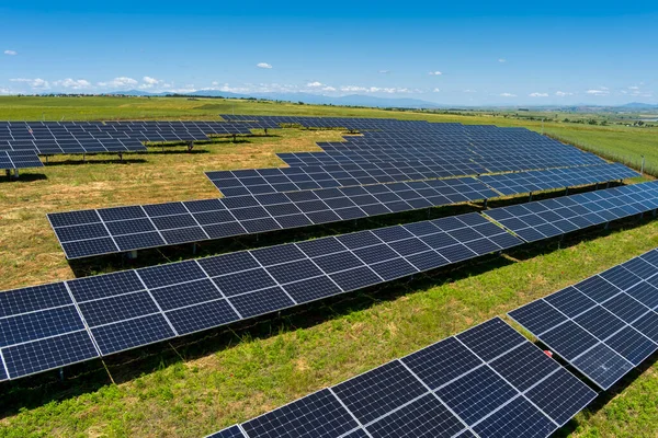北ギリシャの緑のフィールドに空中ビューの太陽光発電パネル公園 太陽電池パネルの列に反映青い空 未来的な代替発電所だ 持続可能なエネルギー源 再生可能エネルギー技術 ストックフォト