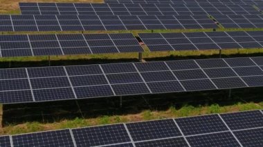Hava manzaralı fotovoltaik paneller Yunanistan 'ın kuzeyinde yeşil alana park ediyorlar. Mavi gökyüzü güneş panellerine yansıyor. Geleceğin alternatif enerji santrali. Sürdürülebilir enerji kaynağı. Yenilenebilir elektrik teknolojisi