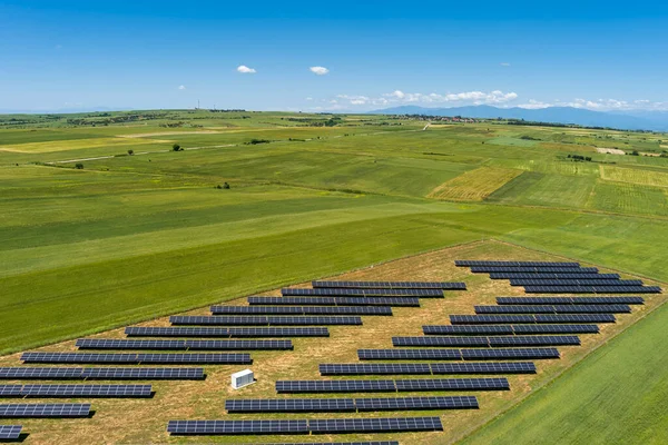 北ギリシャの緑のフィールドに空中ビューの太陽光発電パネル公園 太陽電池パネルの列に反映青い空 未来的な代替発電所だ 持続可能なエネルギー源 再生可能エネルギー技術 — ストック写真